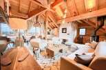 Experience the warmth of this stunning chalet, featuring exposed wooden beams and a cozy fireplace.