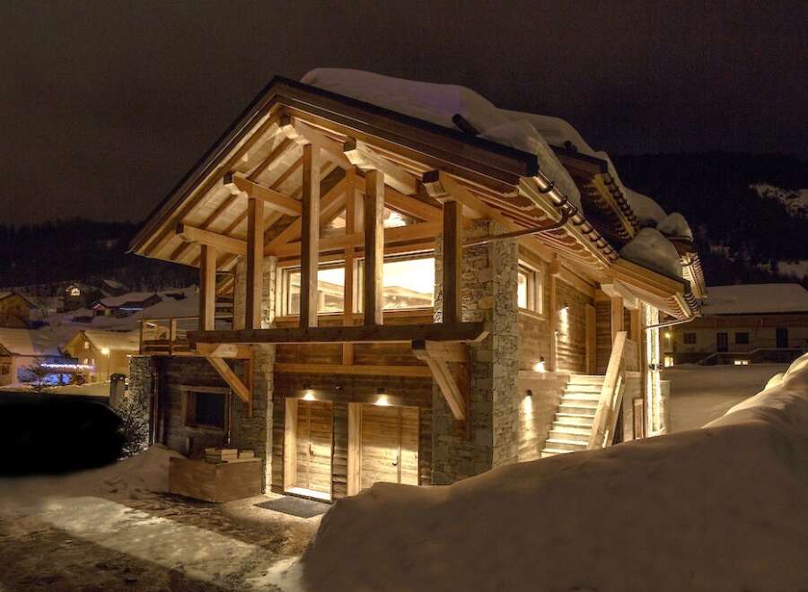 Experience the charm of this stunning wooden chalet nestled in a snowy landscape.