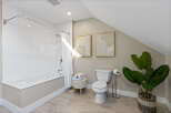 Step into this beautifully designed bathroom, featuring a modern bathtub and a sleek toilet.