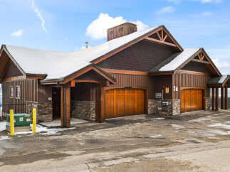 This stunning property boasts a beautiful exterior with a combination of wood and stone accents, creating a warm and inviting atmosphere.