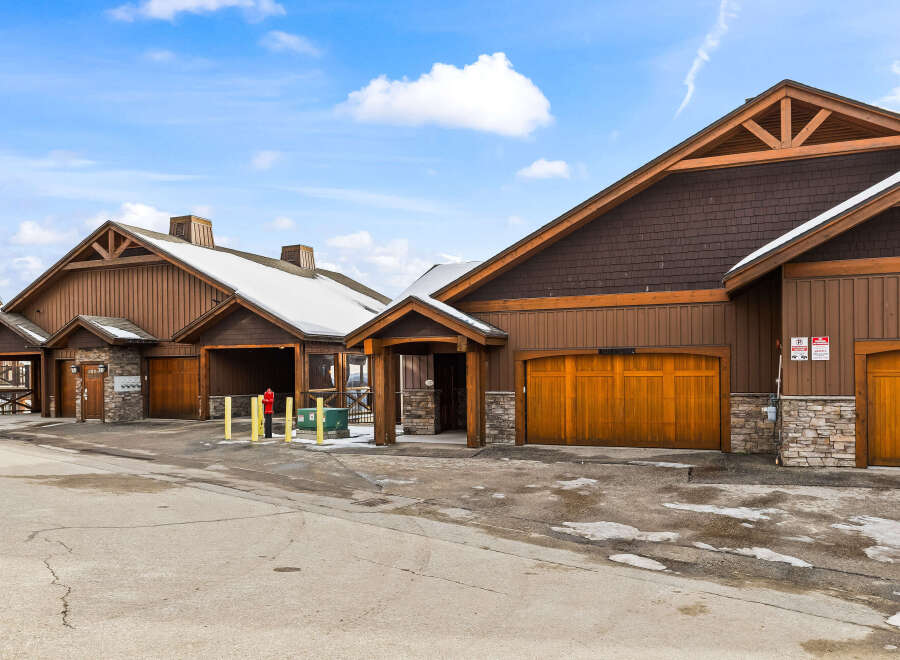 Discover a stunning property featuring beautiful wooden garage doors and a charming exterior design.