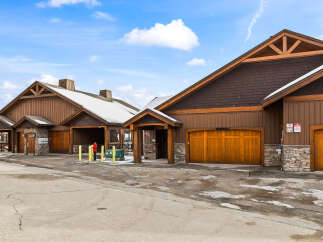 Discover a stunning property featuring beautiful wooden garage doors and a charming exterior design.