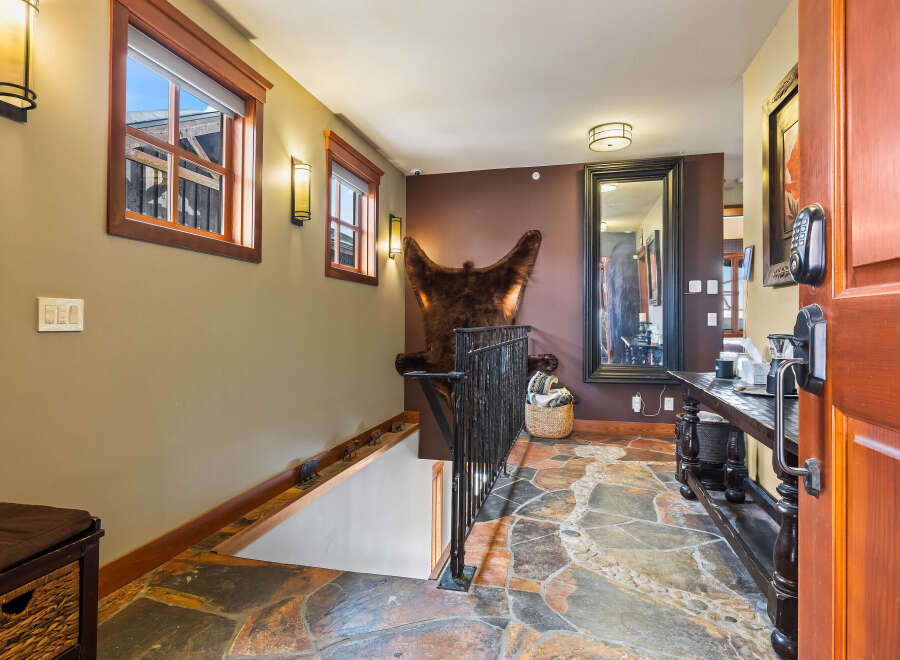 Step into luxury with this stunning entryway, featuring a unique stone floor and a grand mirror.