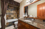 This stunning bathroom boasts a luxurious design with a beautiful stone tile shower and a granite countertop vanity.