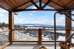 Enjoy breathtaking views from this stunning property, featuring a spacious balcony with a wooden frame.