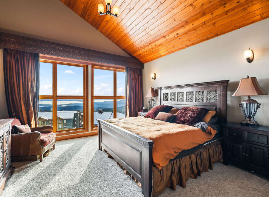 Experience luxury in this stunning bedroom with breathtaking mountain views.