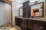 This luxurious bathroom boasts a stunning dark wood vanity with ample storage, complemented by a beautiful granite countertop.
