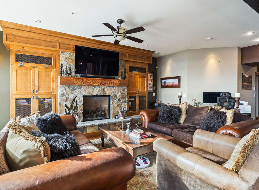 This stunning living room boasts a cozy fireplace with a stone facade, perfect for those chilly evenings.