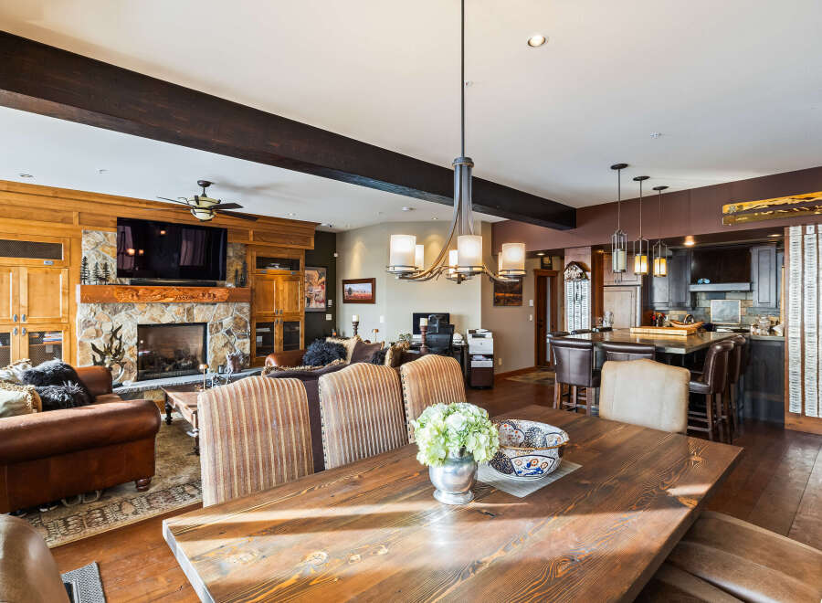 This stunning property boasts a spacious living area with a cozy fireplace and a large dining table, perfect for entertaining.