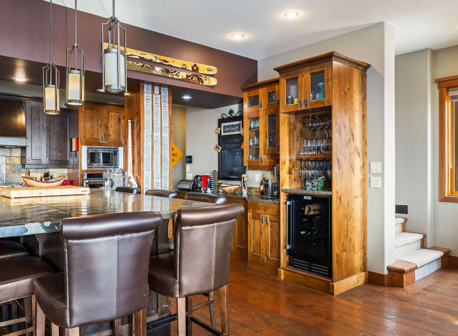 This stunning kitchen boasts a luxurious granite countertop island with comfortable bar stools, perfect for entertaining.