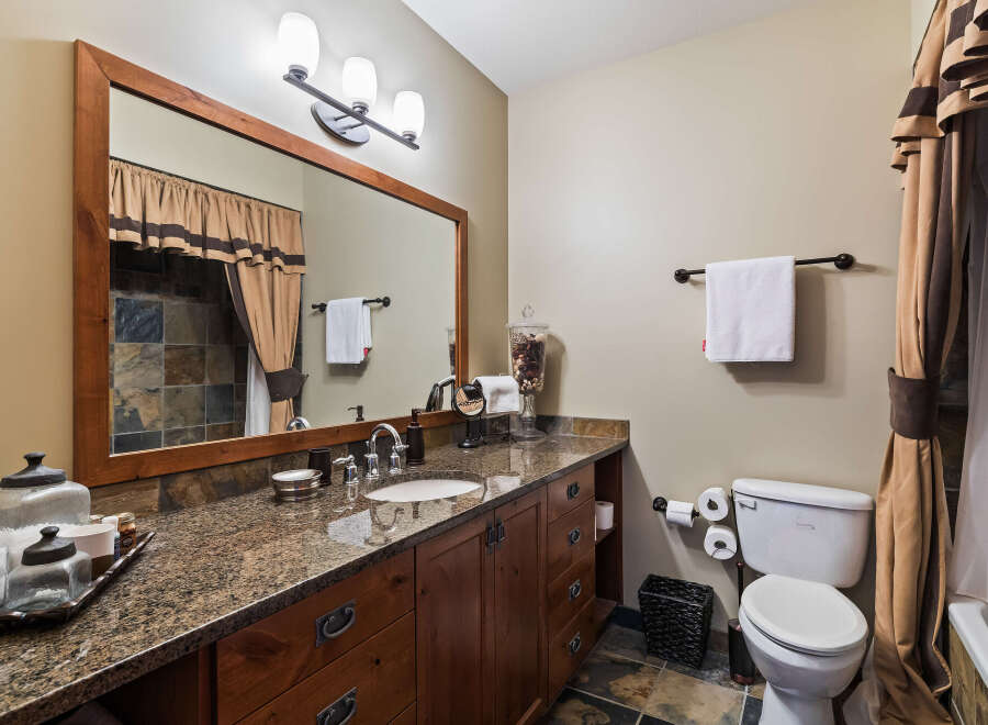 This stunning bathroom boasts a luxurious vanity with a granite countertop and ample storage.
