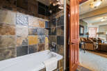 Step into luxury with this stunning bathroom featuring a beautiful tile surround and a relaxing soaking tub.
