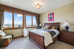 This stunning bedroom boasts a luxurious ambiance with its elegant wooden bed frame and plush bedding.