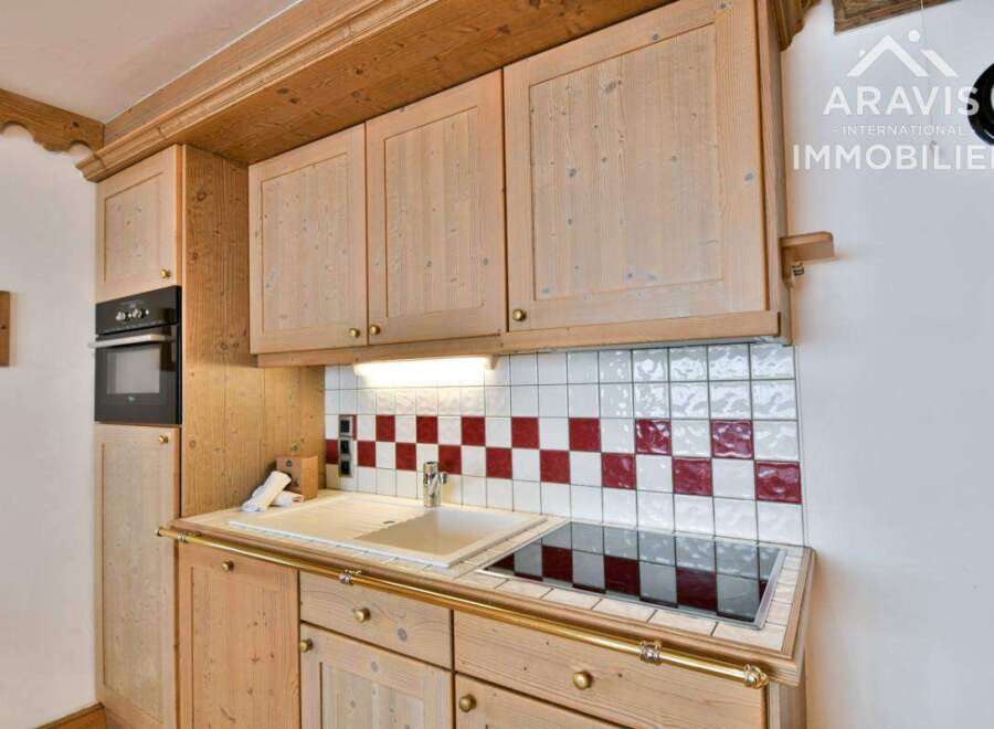 This charming kitchen features beautiful wooden cabinetry and a stylish tiled backsplash.
