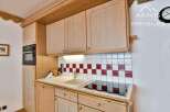 This charming kitchen features beautiful wooden cabinetry and a stylish tiled backsplash.