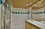 This charming bathroom features a stylish design with a wooden ceiling and a modern sink.