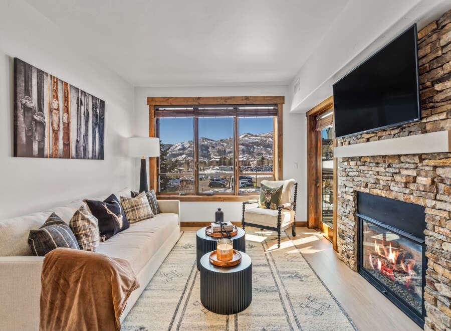 Experience luxury living in this stunning property, featuring a cozy fireplace and a modern TV setup.