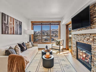 Experience luxury living in this stunning property, featuring a cozy fireplace and a modern TV setup.
