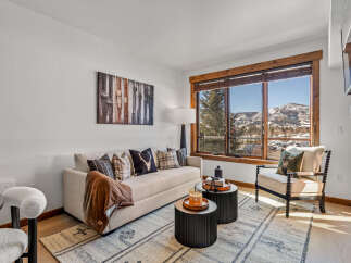 This stunning living room boasts a cozy ambiance with a comfortable sofa and stylish accent pillows.