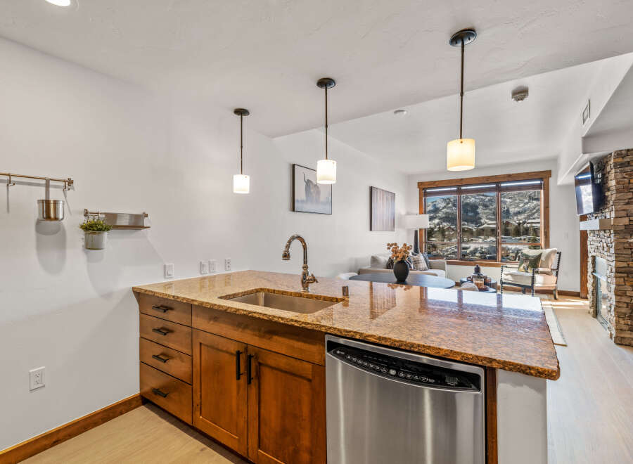 This stunning kitchen features a beautiful granite countertop and stainless steel appliances, perfect for preparing meals and entertaining guests.