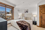 This luxurious bedroom features a cozy ambiance with a plush bed and a warm, inviting fur throw.