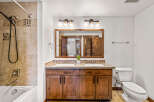 This stunning bathroom boasts a luxurious double vanity with a granite countertop and elegant wooden cabinetry.