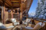 Enjoy the serene beauty of this stunning chalet, complete with a cozy outdoor seating area.