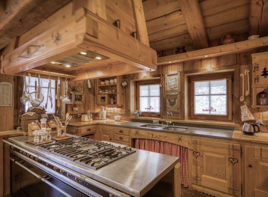 This stunning kitchen showcases rustic charm with its warm wooden cabinetry and exposed beams, creating a cozy and inviting atmosphere.