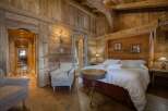 Step into rustic elegance with this stunning bedroom, showcasing exquisite wooden paneling and a cozy ambiance.