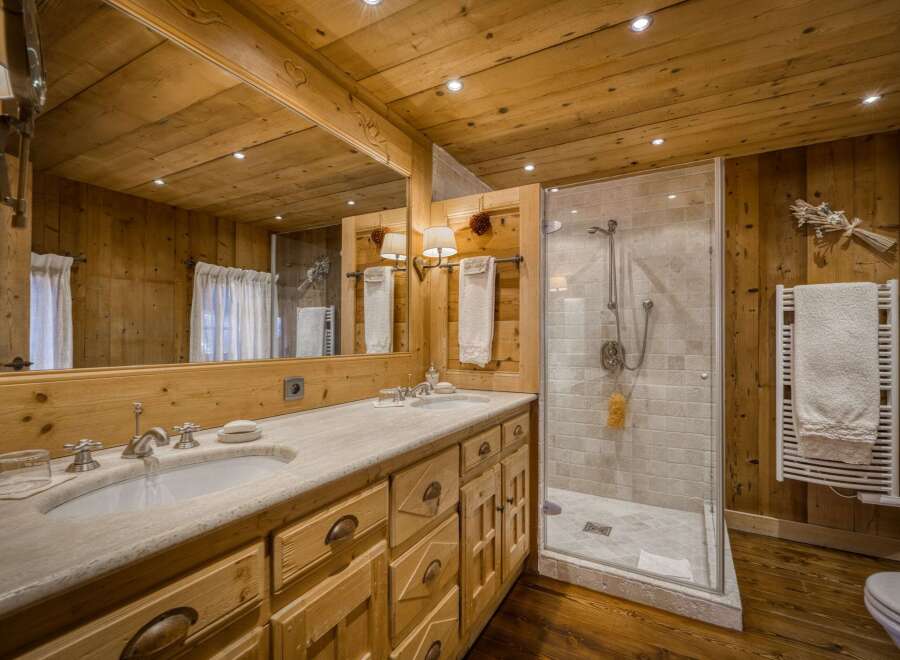 This stunning bathroom showcases a rustic, yet elegant design with its warm wooden walls and ceiling.