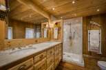 This stunning bathroom showcases a rustic, yet elegant design with its warm wooden walls and ceiling.