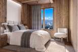 Experience the ultimate mountain retreat in this cozy bedroom, featuring rustic wood paneling and a plush bed perfect for unwinding after a day on the slopes.