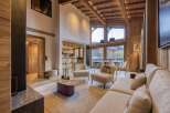 Experience luxury living in this stunning chalet, featuring a warm and inviting interior with wooden accents throughout.