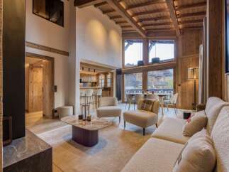 Experience luxury living in this stunning chalet, featuring a warm and inviting interior with wooden accents throughout.
