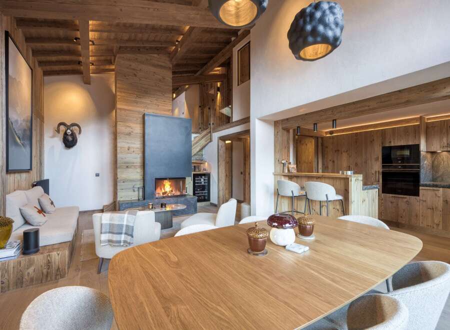 Experience luxury living in this stunning chalet, featuring a cozy fireplace and a modern kitchen.