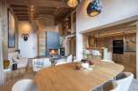 Experience luxury living in this stunning chalet, featuring a cozy fireplace and a modern kitchen.