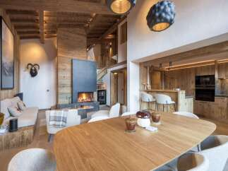 Experience luxury living in this stunning chalet, featuring a cozy fireplace and a modern kitchen.