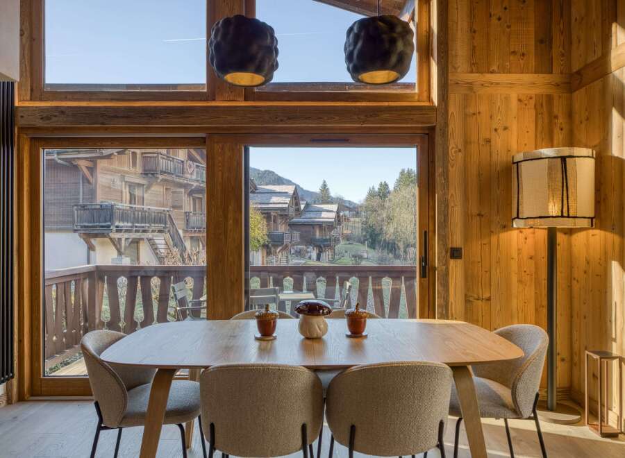 Experience the charm of this stunning property, featuring a beautifully designed dining area with a wooden table and stylish chairs.