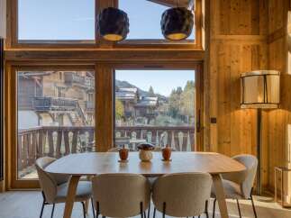 Experience the charm of this stunning property, featuring a beautifully designed dining area with a wooden table and stylish chairs.