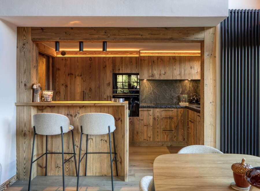 This stunning kitchen showcases rustic elegance with its warm wooden cabinetry and bar area.