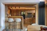 This stunning kitchen showcases rustic elegance with its warm wooden cabinetry and bar area.
