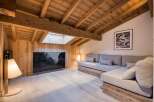 This stunning living space boasts a cozy, rustic charm with its wooden beamed ceiling and walls.