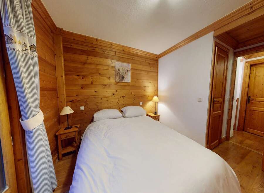 This cozy bedroom features a warm wooden interior, creating a rustic and inviting atmosphere.
