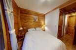 This cozy bedroom features a warm wooden interior, creating a rustic and inviting atmosphere.