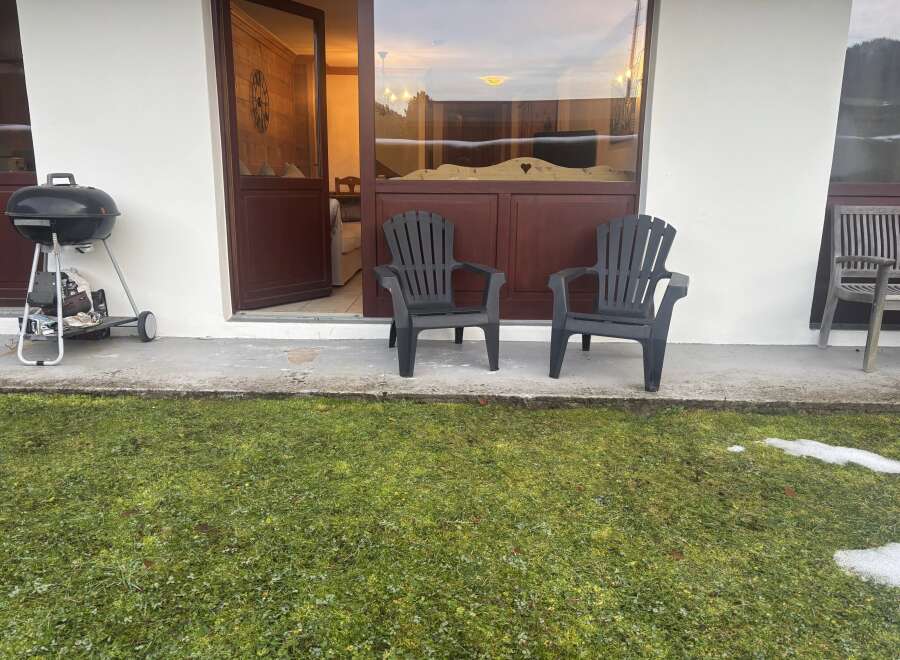 Enjoy outdoor living with this charming property, featuring a cozy patio and lush green lawn.