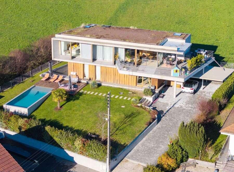 Discover modern luxury in this stunning home, featuring a sleek design and a lush green roof.