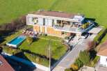 Discover modern luxury in this stunning home, featuring a sleek design and a lush green roof.
