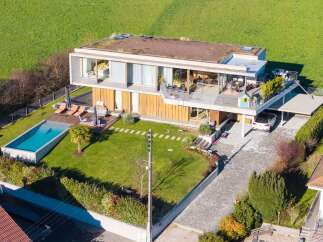 Discover modern luxury in this stunning home, featuring a sleek design and a lush green roof.