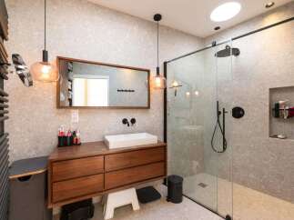 This modern bathroom boasts a sleek design with a wooden vanity and a frameless glass shower.