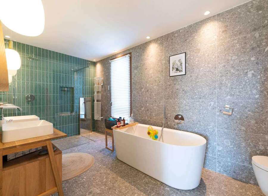 This stunning bathroom boasts a modern design with a luxurious freestanding bathtub, perfect for relaxation.
